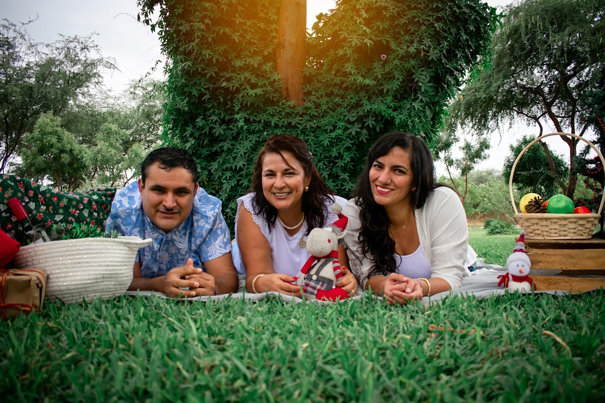 a group of people laying on top of a lush green field